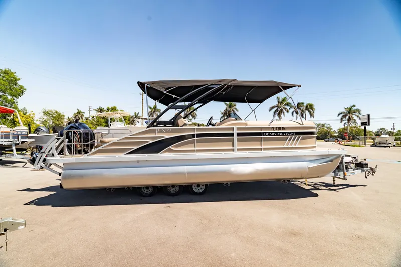 Slide: The Image of 2022 Bennington LX 24 Swingback pontoon boat with canopy, parked outdoors. - 8