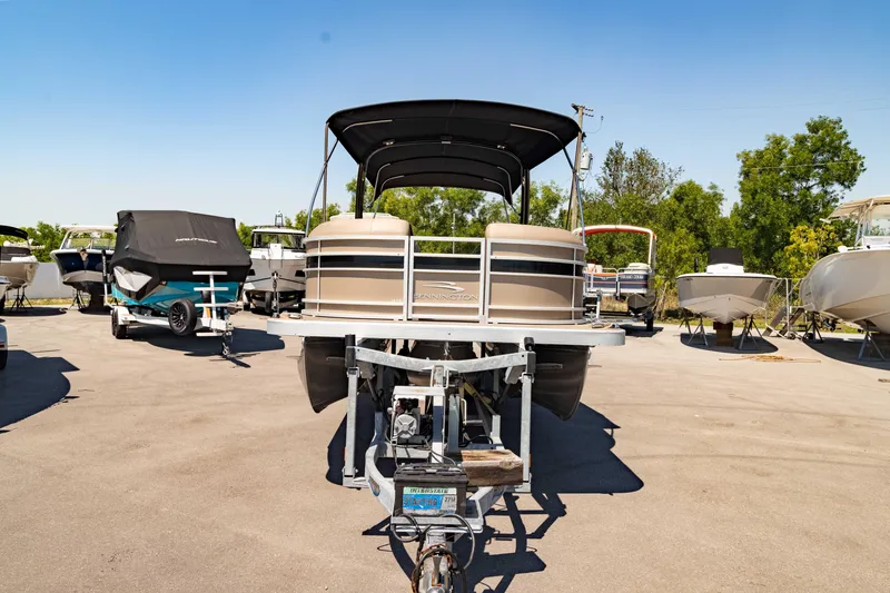 Slide: The Image of 2022 Bennington LX 24 Swingback pontoon boat on trailer in sunny outdoor setting. - 9