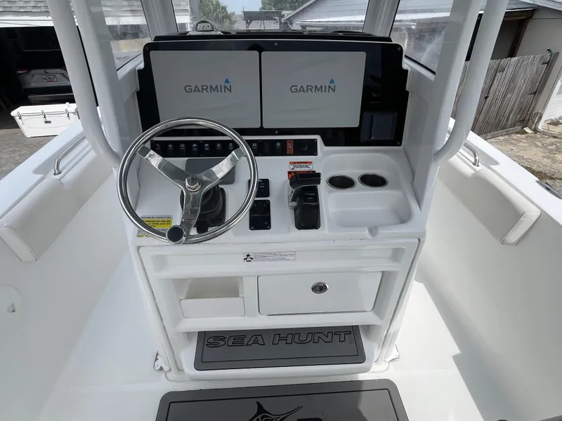 Slide: The Image of 2019 Sea Hunt 235 SE boat dashboard with Garmin displays and steering wheel. - 11