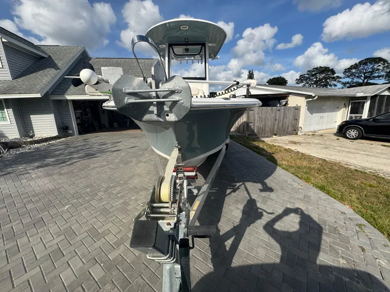 Slide: The Image of 2019 Sea Hunt 235 SE boat on trailer in driveway, under a partly cloudy sky. - 13