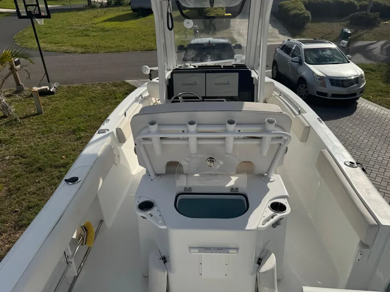 Slide: The Image of 2019 Sea Hunt 235 SE boat interior with console and seating, parked on driveway. - 26