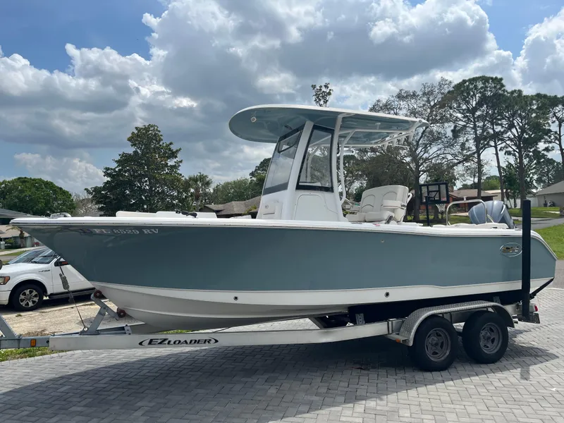 Slide: The Image of 2019 Sea Hunt 235 SE boat on trailer, parked outdoors under cloudy sky. - 3