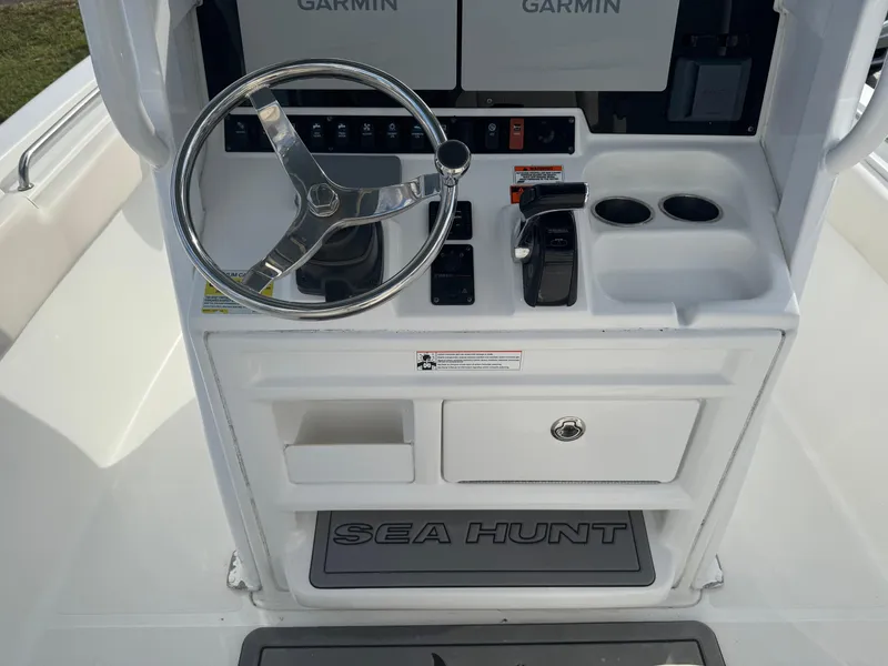Slide: The Image of 2019 Sea Hunt 235 SE boat console with steering wheel, Garmin displays, and control panel. - 31
