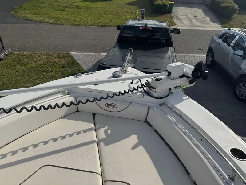 Slide: The Image of 2019 Sea Hunt 235 SE boat with trolling motor, parked near vehicles on a sunny day. - 37
