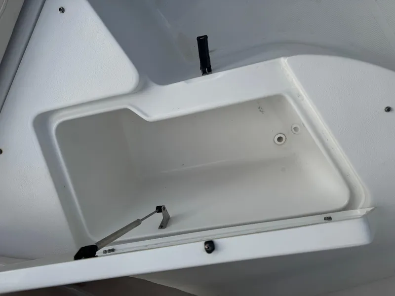 Slide: The Image of Storage compartment in a 2019 Sea Hunt 235 SE boat, featuring a white interior. - 40
