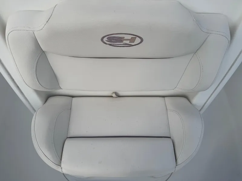 Slide: The Image of 2019 Sea Hunt 235 SE boat seat with logo, featuring cushioned design and light upholstery. - 47