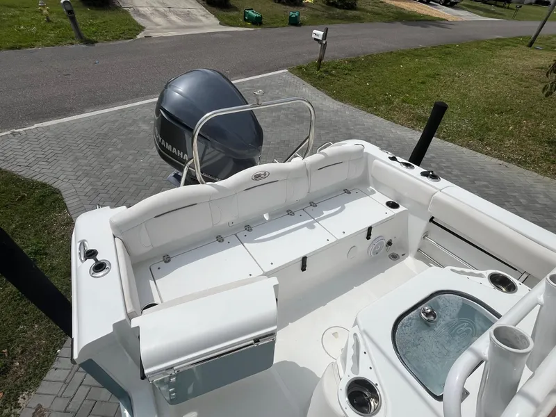 Slide: The Image of 2019 Sea Hunt 235 SE boat with Yamaha engine, parked on a paved driveway. - 6