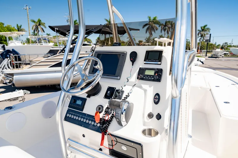 Slide: The Image of 2015 Edgewater 240 Inshore boat console with steering wheel and navigation equipment. - 16