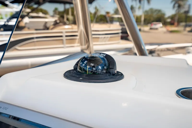 Slide: The Image of Compass on 2015 Edgewater 240 Inshore boat, with marina background. - 17