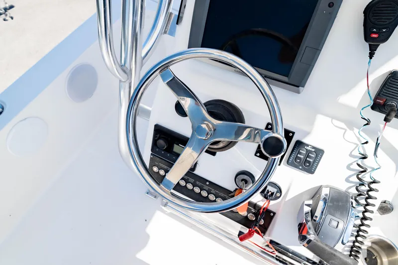 Slide: The Image of Steering wheel and controls of a 2015 Edgewater 240 Inshore boat. - 23