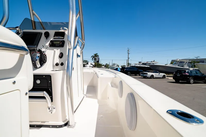Slide: The Image of 2015 Edgewater 240 Inshore boat interior with control panel and seating, parked outdoors. - 36