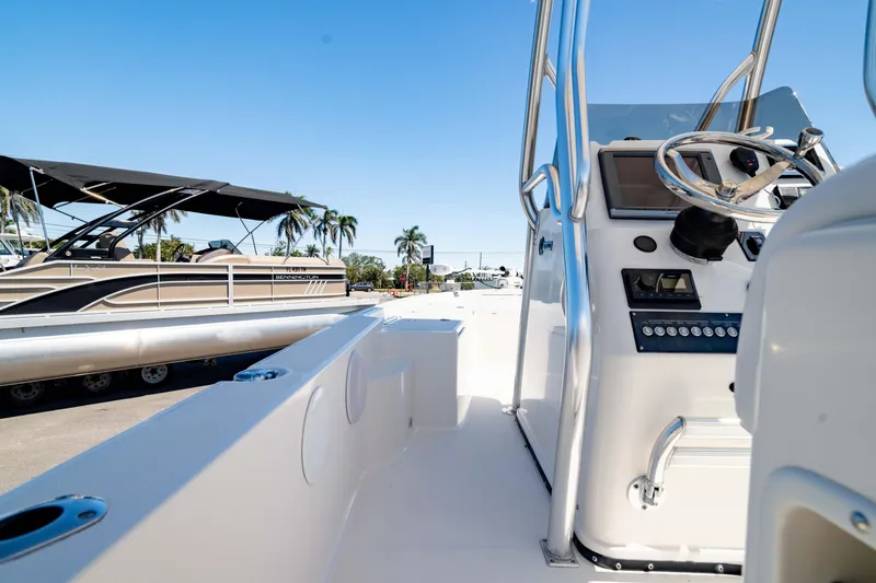 Slide: The Image of 2015 Edgewater 240 Inshore boat interior with steering console, sunny day. - 37
