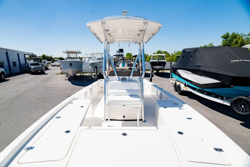 Slide: The Image of 2015 Edgewater 240 Inshore boat with T-top, parked in a marina under clear blue sky. - 4