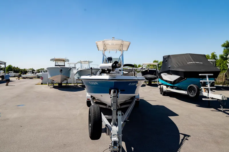 Slide: The Image of 2015 Edgewater 240 Inshore boat on trailer in sunny marina setting. - 41
