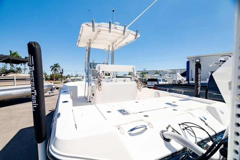 Slide: The Image of 2015 Edgewater 240 Inshore boat with T-top, parked on trailer under clear blue sky. - 46