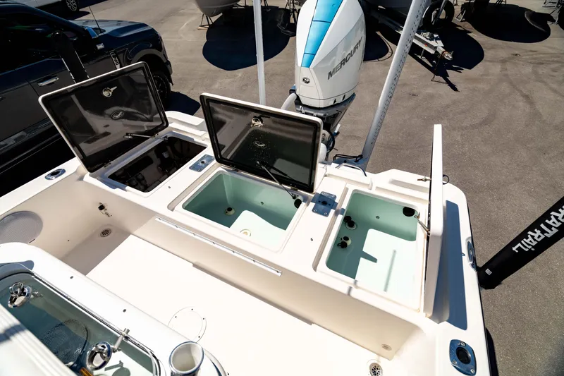 Slide: The Image of 2015 Edgewater 240 Inshore boat with open storage compartments and outboard motor. - 8