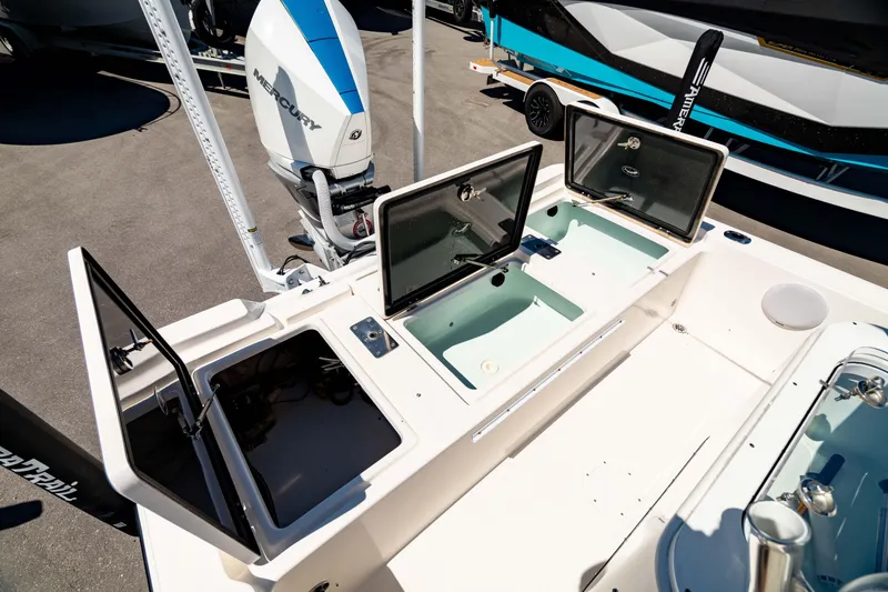 Slide: The Image of 2015 Edgewater 240 Inshore boat with open storage compartments and visible outboard motor. - 9