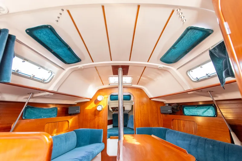 Slide: The Image of Interior of 1995 Beneteau Oceanis 321 sailboat with wood finish and blue seating. - 46