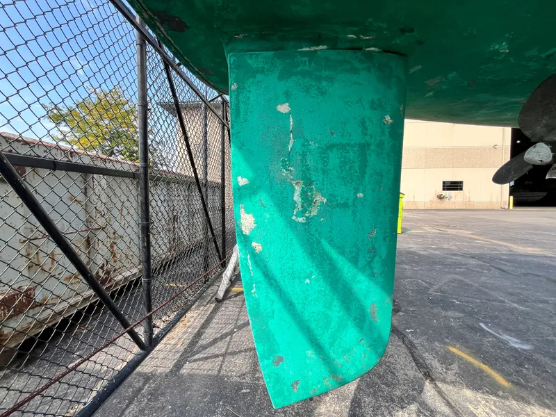 Slide: The Image of Rudder of a 1995 Beneteau Oceanis 321 sailboat, showing wear and paint chipping. - 76