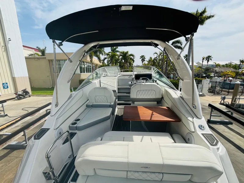 Slide: The Image of 2023 Regal 26XO boat interior with seating and table, docked under sunny skies. - 5