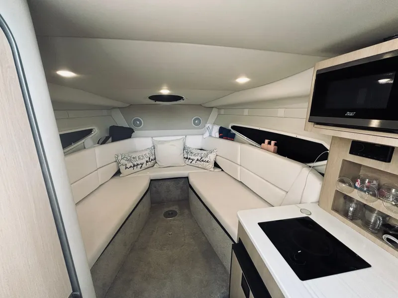 Slide: The Image of 2023 Regal 26XO boat interior with cozy seating, kitchenette, and modern amenities. - 9