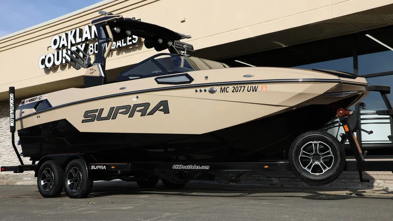 Slide: The Image of 2023 Supra SL boat on trailer at dealership, showcasing sleek design and modern features. - 11