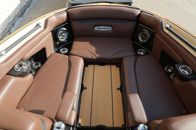 Slide: The Image of 2023 Supra SL boat interior with brown leather seating and cup holders. - 7