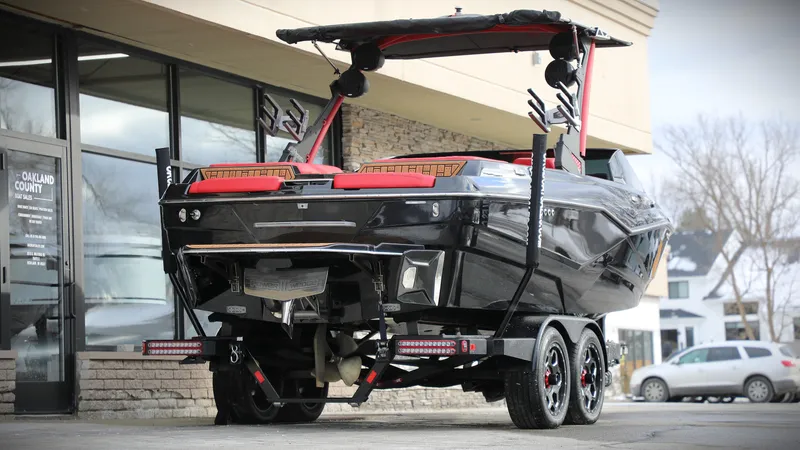 Slide: The Image of 2023 Malibu Wakesetter 22 LSV boat on trailer, rear view, black and red design. - 1