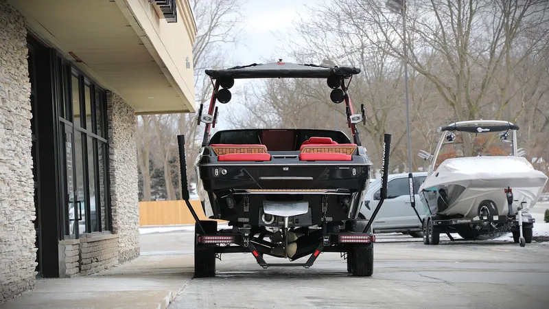 Slide: The Image of 2023 Malibu Wakesetter 22 LSV boat on trailer, parked near building. - 10