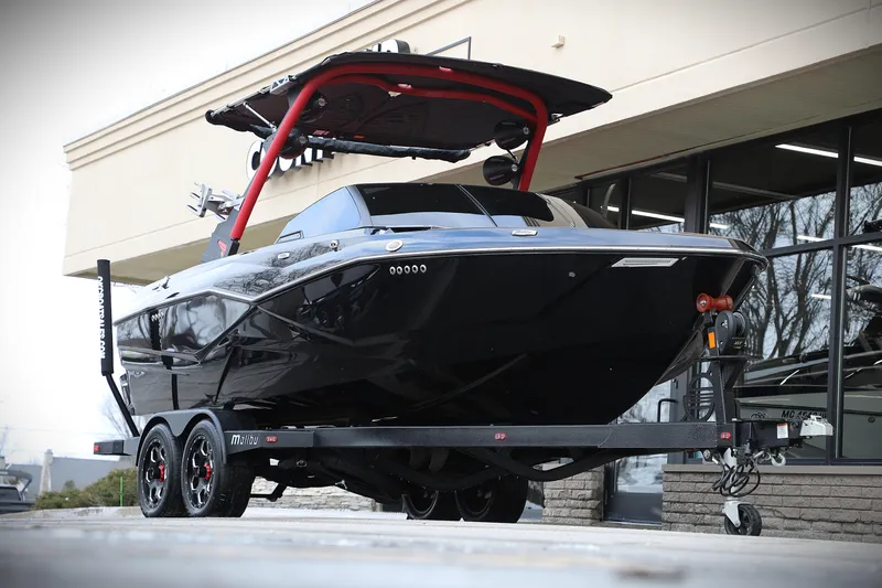 Slide: The Image of 2023 Malibu Wakesetter 22 LSV boat on trailer, black with red accents, parked outside. - 8