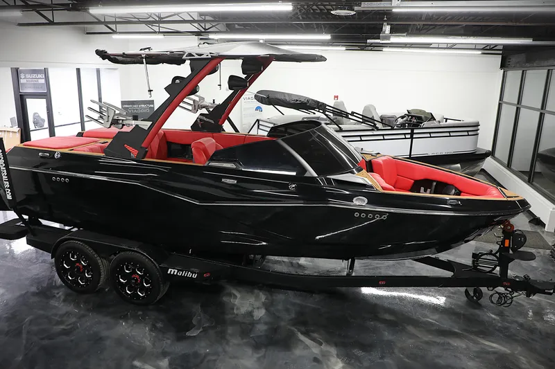 Slide: The Image of 2023 Malibu Wakesetter 22 LSV boat in showroom, sleek black design with red interior. - 9