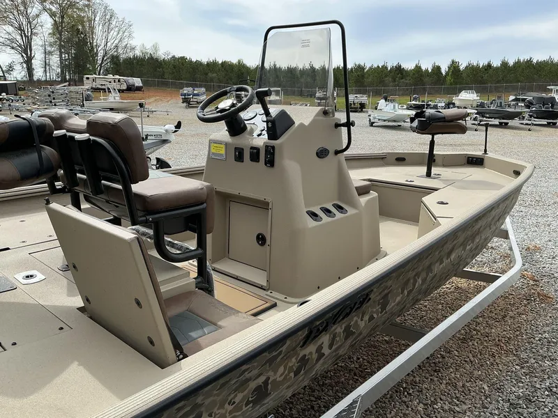 Slide: The Image of 2025 Excel Bay Pro 203 ELITE boat with console and seating, parked on gravel lot. - 7