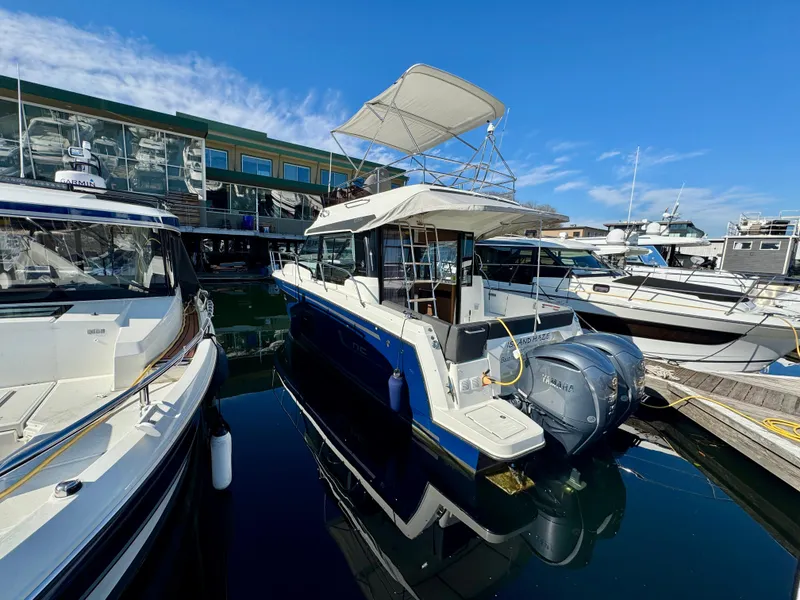 The Image of 2023 Jeanneau NC 1095 Fly yacht docked at marina under clear blue sky. - 1