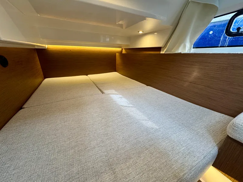Slide: The Image of 2023 Jeanneau NC 1095 Fly cabin interior with cozy bed and ambient lighting. - 12