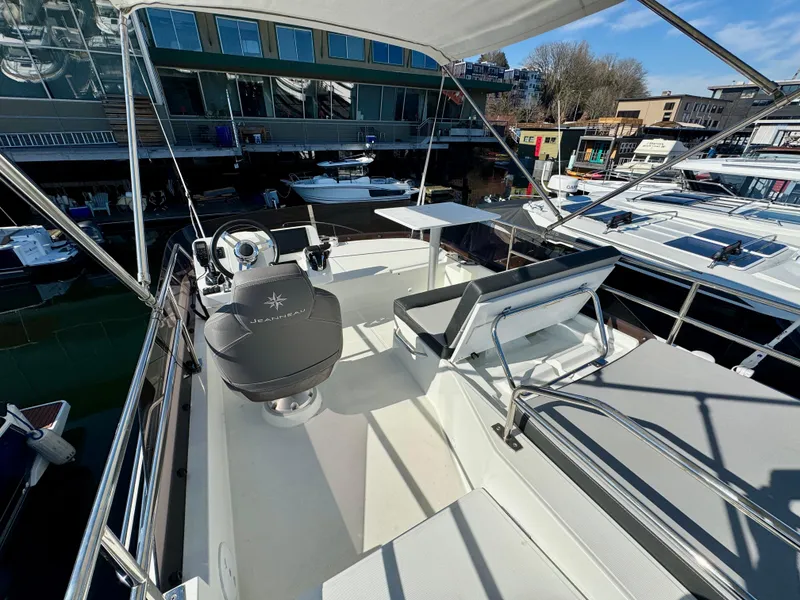 Slide: The Image of 2023 Jeanneau NC 1095 Flybridge with seating and helm, docked at a marina. - 17