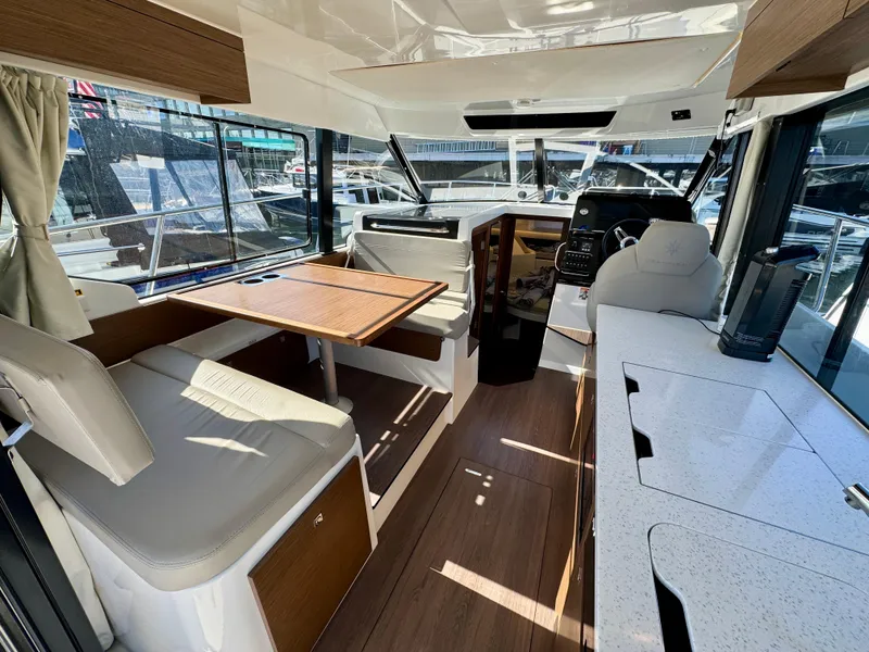 Slide: The Image of Interior of 2023 Jeanneau NC 1095 Fly boat with seating, table, and helm station. - 6