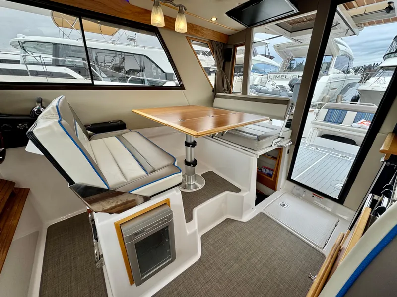 Slide: The Image of 2018 Cutwater C-30 CB interior with dining area, cushioned seating, and large windows. - 17