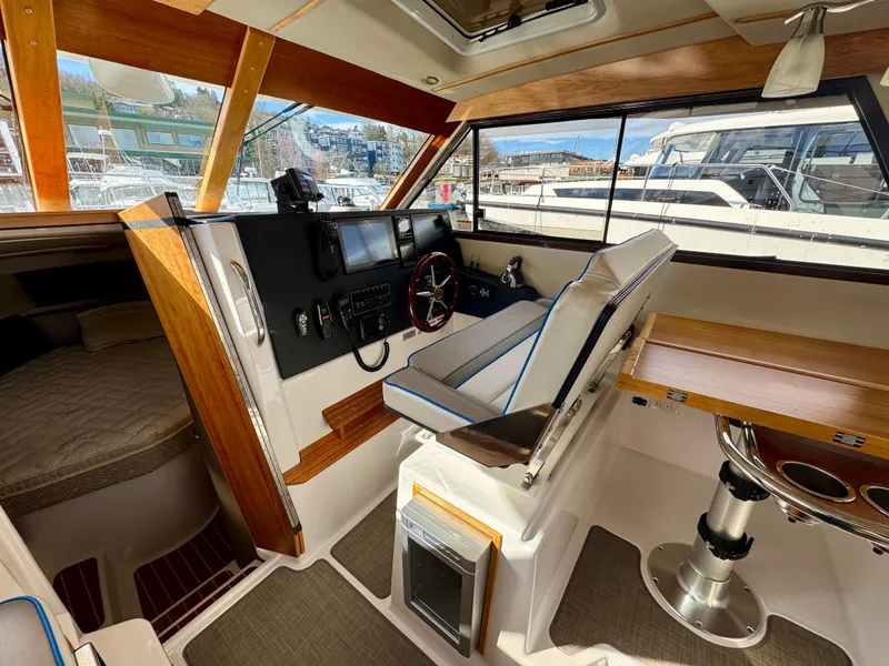 Slide: The Image of 2018 Cutwater C-30 CB boat interior with helm, seating, and wood accents. - 19