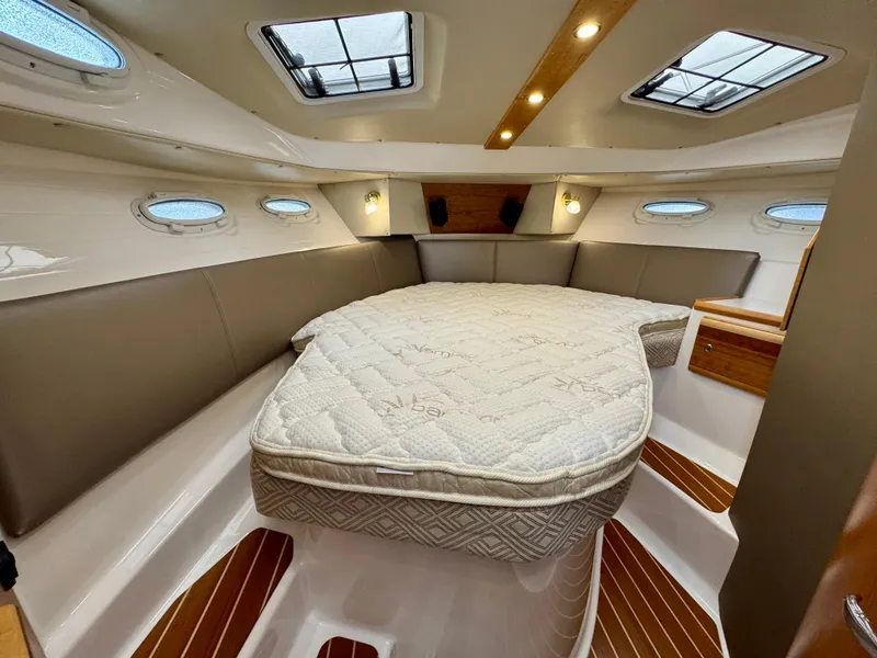Slide: The Image of 2018 Cutwater C-30 CB cabin interior with bed, skylights, and wood accents. - 20
