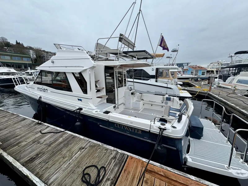 Slide: The Image of 2018 Cutwater C-30 CB boat docked at a marina, featuring a spacious deck and modern design. - 6