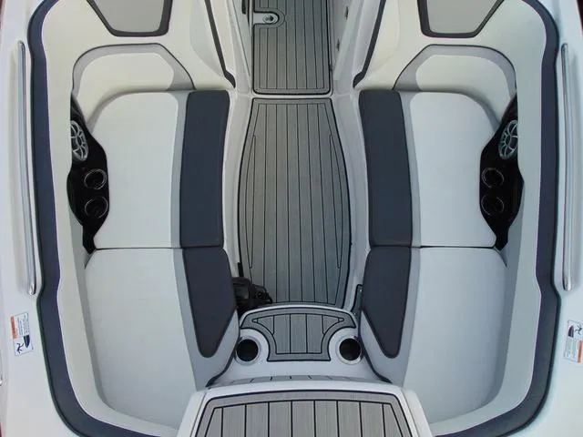 Slide: The Image of 2023 Yamaha Boats 252SD interior with gray seating and flooring, featuring cup holders and speakers. - 26