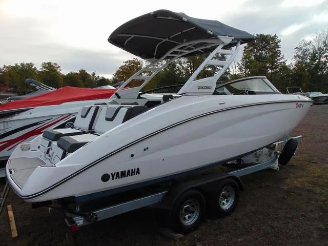 Slide: The Image of 2023 Yamaha Boats 252SD on trailer, sleek design, white exterior, canopy, outdoor setting. - 3