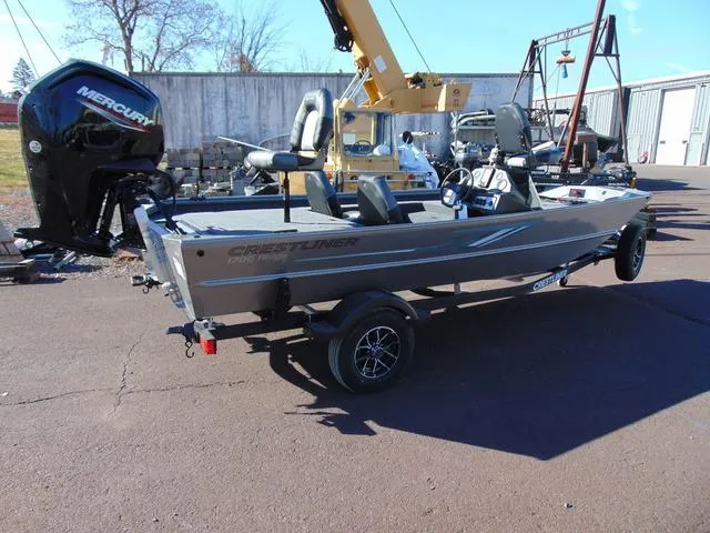 Slide: The Image of 2025 Crestliner 1700 Ridge boat with Mercury engine on trailer, parked outdoors. - 1