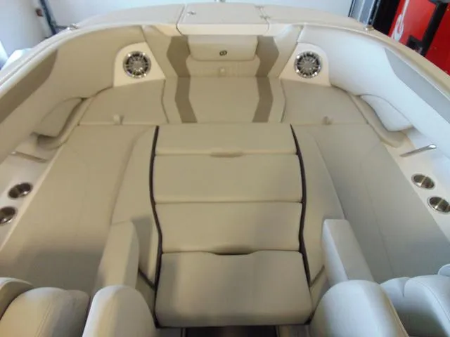 Slide: The Image of 2024 Hurricane SunDeck 2600 OB boat interior with beige seating and cup holders. - 13