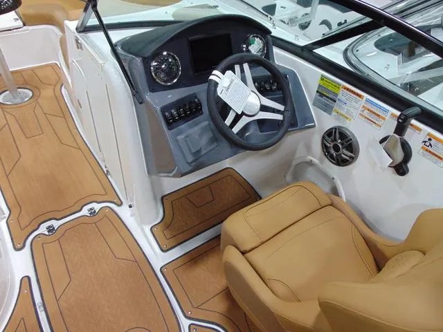 Slide: The Image of 2025 Hurricane SunDeck 2486 OB boat interior with tan seating and modern dashboard. - 5