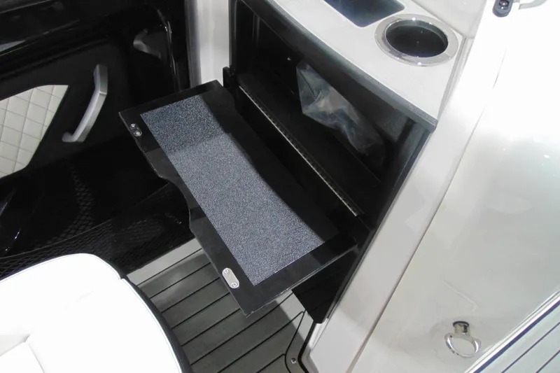 Slide: The Image of 2025 Yamaha Boats 252S interior with open storage compartment and cup holder. - 13