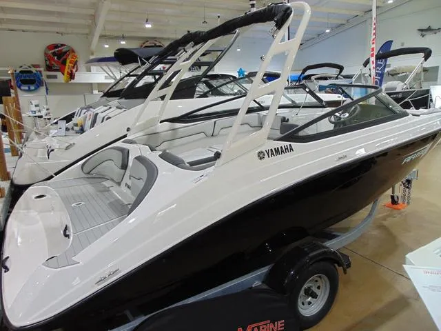 Slide: The Image of 2025 Yamaha Boats AR190 in showroom, sleek design, black and white exterior. - 8
