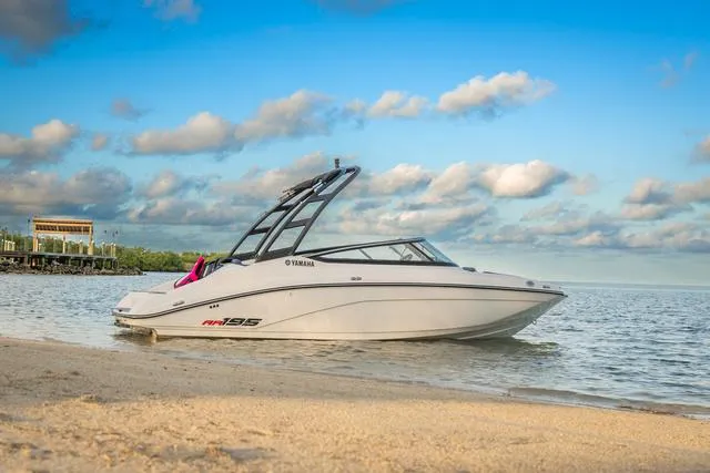 Slide: The Image of 2025 Yamaha AR195 boat on sandy beach with blue sky and clouds. - 8