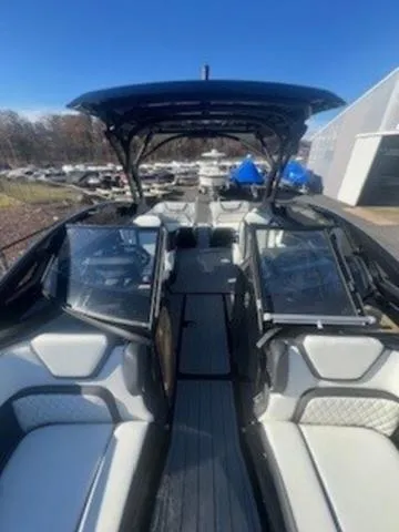 Slide: The Image of 2025 Yamaha Boats 275SD with sleek design and spacious seating, docked outdoors. - 11