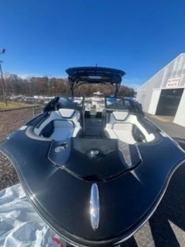 Slide: The Image of 2025 Yamaha Boats 275SD, sleek black design, parked outdoors under clear blue sky. - 5